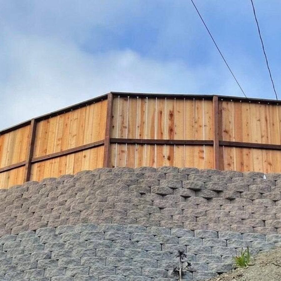Retaining Wall After Expert fence installation by Geico Builders. View of a strong wooden fence from the exterior of a property
