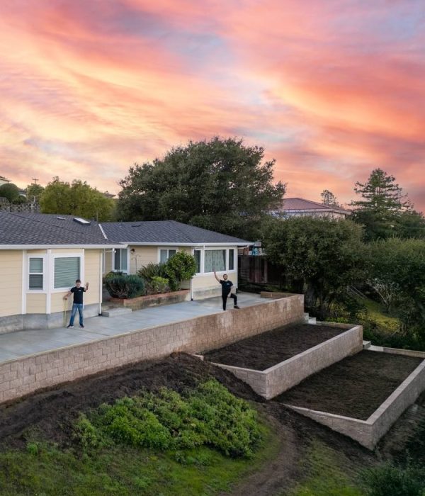 Retaining Wall – King3 Tiered retaining wall expertly installed by Geico Builders. General contractors standing beside the wall with a sunset behind