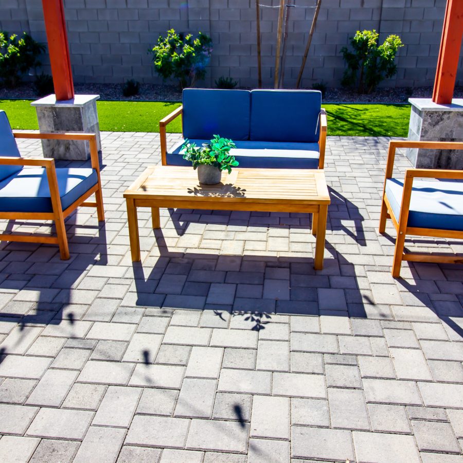 Rear Pavers Patio With Couch, Table And Two chairs Blue patio chairs on a gray paver patio